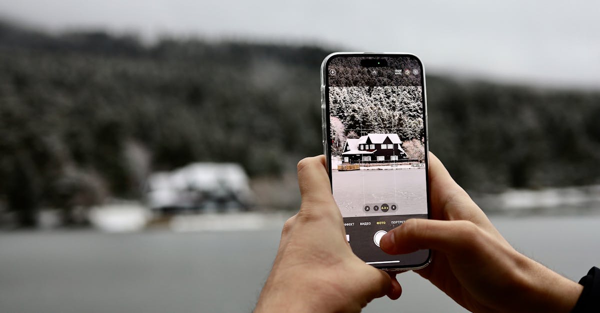 Person photographing snowy landscape with smartphone in Bolu, Turkey.