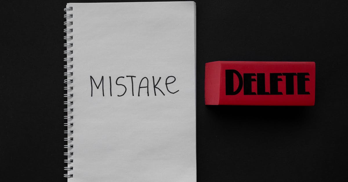 Flat lay of a notebook with 'Mistake' and red eraser labeled 'Delete', minimalist concept.